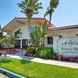 A scenic view of a hotel entrance surrounded by lush landscaping and palm trees on a sunny day.