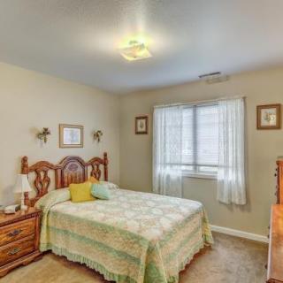A cozy bedroom with a wooden bed, side tables, and a window with curtains.