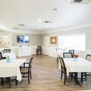 A bright and spacious dining room with neatly arranged tables and chairs.