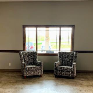 A cozy seating area featuring two patterned chairs placed by a window.