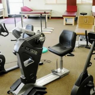 A fitness center with various exercise equipment, including stationary bikes.