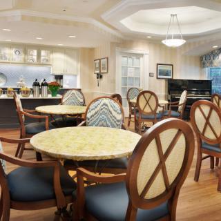 A cozy dining area with elegantly set tables and comfortable chairs.