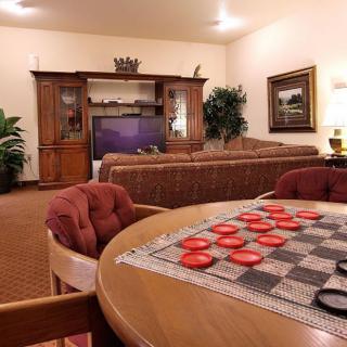 A cozy living room with a checkers board set up on a table.