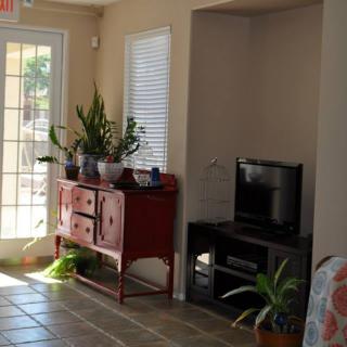 A cozy living room corner featuring a red console with plants and a small television.