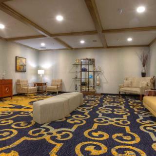 A modern lobby with stylish furniture and intricate carpet design.