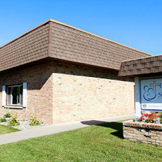 A brick building with a sloped roof and clear blue skies.