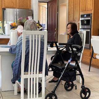 A warm moment shared between two individuals in a kitchen, highlighting care and companionship.