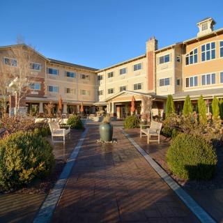 An inviting residential building with landscaped gardens and outdoor seating areas.