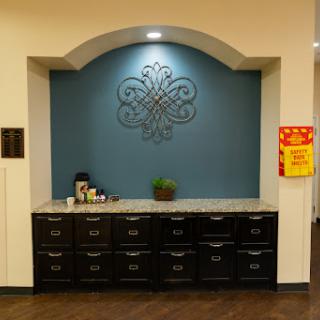 A stylish kitchenette area featuring a blue accent wall and dark cabinetry.