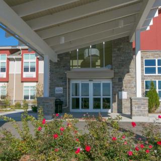 A modern building entrance surrounded by landscaped flowers.