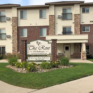 An apartment building with a welcoming entrance and neatly landscaped surroundings.