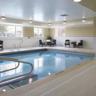 An inviting indoor swimming pool with seating and tables for relaxation.