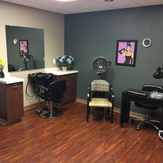 A cozy salon interior with a styling station, mirror, and hairdressing equipment.