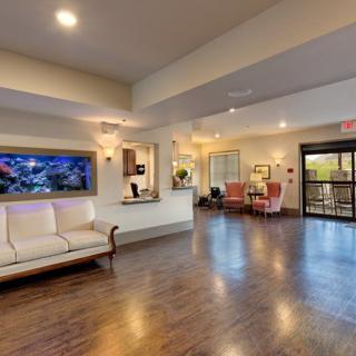 A spacious and well-lit lobby with comfortable seating and a reception desk.