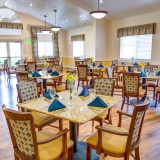 An elegant dining room set with tables and chairs, featuring neatly arranged napkins and inviting decor.