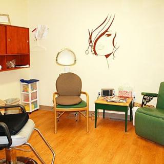 A cozy waiting room with chairs, a table, and wall art.