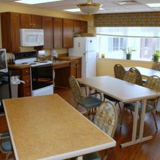 A spacious kitchen and dining area with tables, chairs, and appliances.