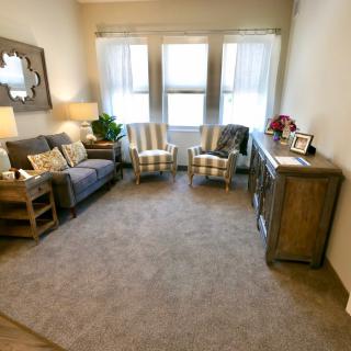 A cozy and well-decorated living room with a sofa, chairs, and warm lighting.