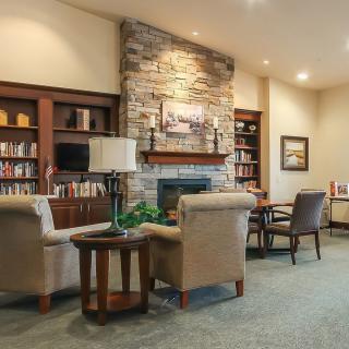 A cozy living room with a stone fireplace and comfortable seating.