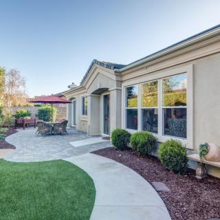 A well-maintained backyard featuring a patio with outdoor furniture and a landscaped garden.