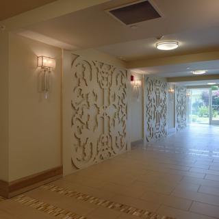 A modern hallway featuring decorative wall panels and soft lighting.