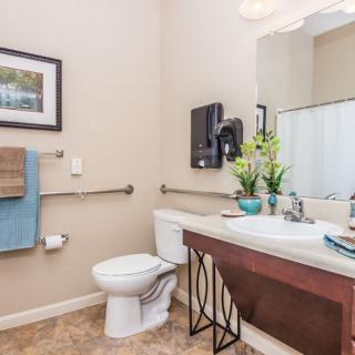 A modern bathroom featuring a toilet, sink, and mirror with decorative elements.