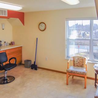 A bright salon interior with a hairdressing station and seating area.
