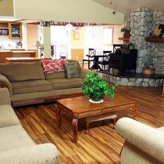 A cozy living room featuring a sofa set, coffee table, and fireplace with wooden flooring.