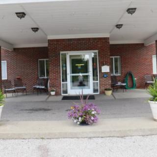 Entrance of a building with a covered porch and potted plants.