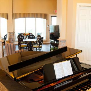 A cozy music room with a grand piano and seating area.