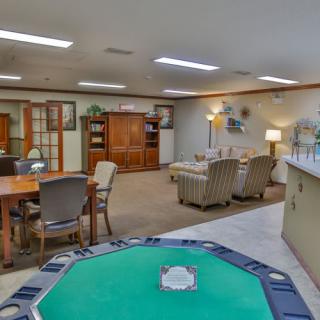 A cozy living room featuring a game table and comfortable seating area.