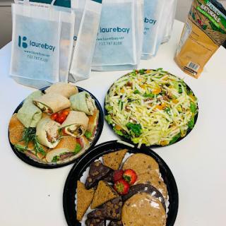 A colorful assortment of lunch options including wraps, salad, and cookies.