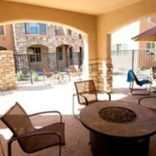 A cozy outdoor patio with a fire pit and comfortable seating in a residential setting.