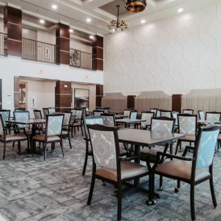 A spacious and modern dining area with neatly arranged tables and chairs.