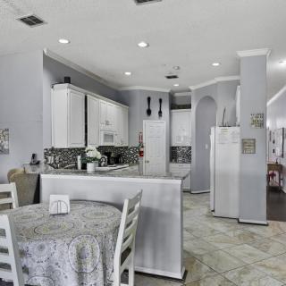 A modern kitchen and dining area featuring white cabinets and contemporary decor.