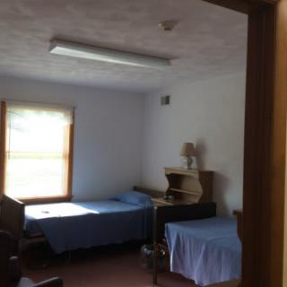A simple room with two single beds and a desk by the window.
