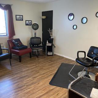 A cozy and inviting salon waiting area featuring comfortable seating and stylish decor.