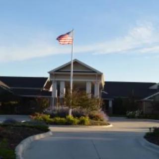 A building with an American flag flying in front of it, set against a clear sky.