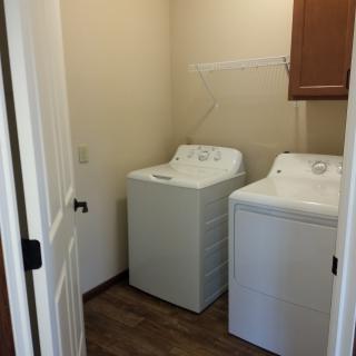 A compact laundry room featuring a washer and dryer side by side.