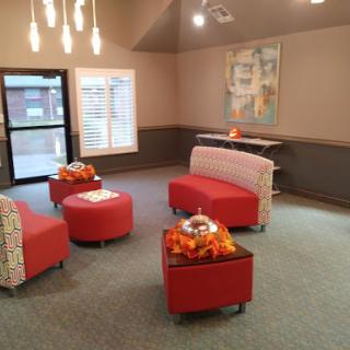 A stylish lounge area featuring modern red furniture and ambient lighting.