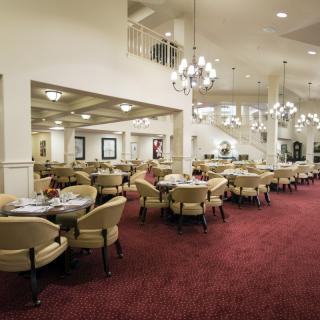 Elegant dining area with chandeliers and plush carpeting.