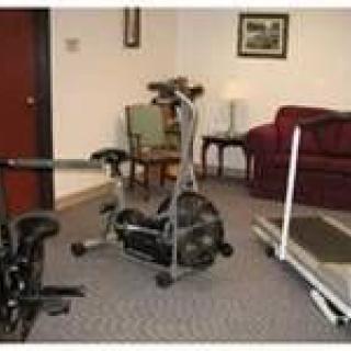 A home gym setup with exercise equipment and furniture.