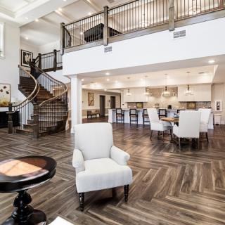 A spacious open-concept interior with modern design, featuring a living area, dining space, and kitchen with a prominent staircase.