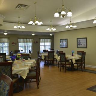 A well-lit dining area with neatly arranged tables and chairs.