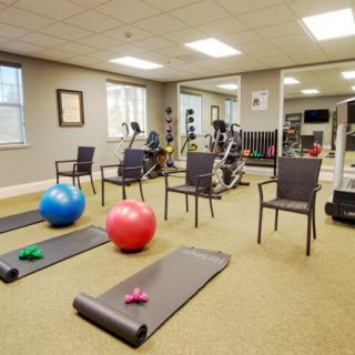 A gym room equipped with exercise balls, yoga mats, and various fitness equipment.