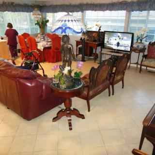 A spacious living room with elegant furniture and a dining area in the background.