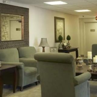A cozy living room setting with armchairs, a mirror, and decorative elements.