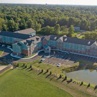 Aerial view of a large hotel complex surrounded by trees and a pond.