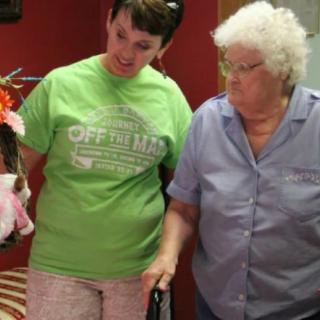 A younger woman and an elderly woman interacting indoors.