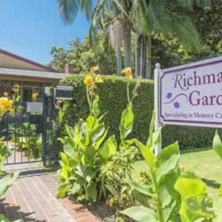 Entrance to Richman Gardens with vibrant yellow flowers and welcoming greenery.